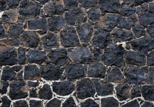 Fototapeta - Mroczny urok - kompozycja o teksturze czarnych kamieni z jasną fugą